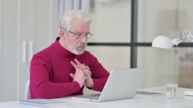 Dizüstü bilgisayarda çalışırken düşünen yaratıcı yaşlı adam 