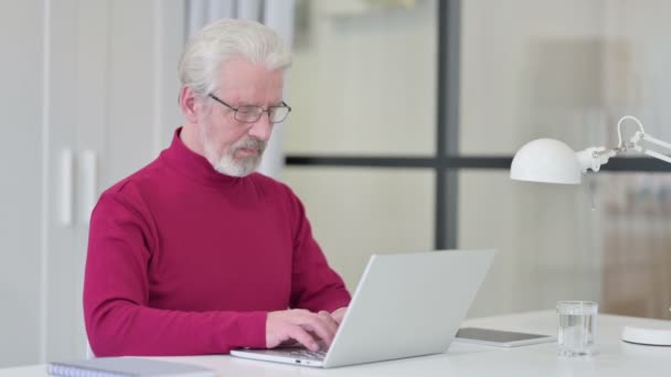 Dizüstü bilgisayarlı yaratıcı yaşlı adam kamerayı işaret ediyor — Stok video