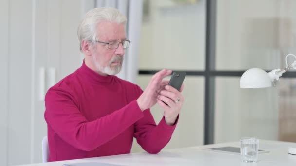 Kreativer alter Mann nutzt Smartphone bei der Arbeit — Stockvideo