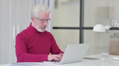 Dizüstü bilgisayarlı Yaratıcı Yaşlı Adam 'dan Başparmak İndirme 