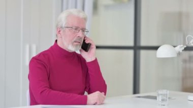 Yaratıcı Yaşlı Adam İş yerinde Akıllı Telefonla Konuşuyor 