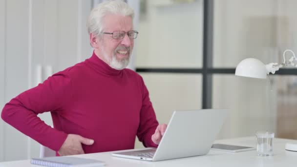 Tvůrčí starý muž s bolestí zad při práci na notebooku — Stock video