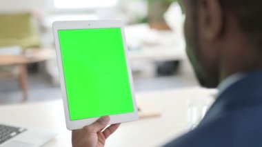 Yeşil Krom Anahtarlı Tablet kullanan İşadamı