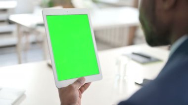 Yeşil Krom Anahtarlı Tablet kullanan İşadamı