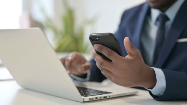 Empresário Africano com Laptop usando Smartphone, Fechar — Vídeo de Stock