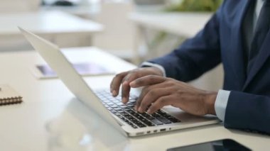 Dizüstü bilgisayarda yazan Afrikalı iş adamının elleri. Kapat. 