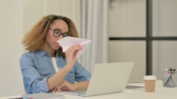 Африканська жінка літить за папером під час роботи в офісі — стокове відео