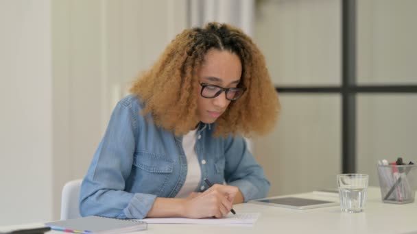 Hardwerkende Afrikaanse vrouw en schrijven op papier — Stockvideo