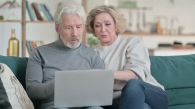 Yaşlı Yaşlı çift dizüstü bilgisayar ve ev işleri ile uğraşırken heyecanlandı 