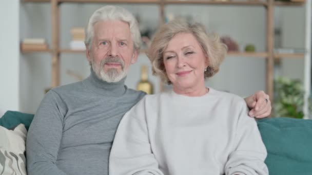 Senior Old Couple Zittend op de bank en glimlachend op de camera — Stockvideo