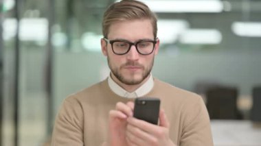 Akıllı telefon kullanan genç yaratıcı adam.