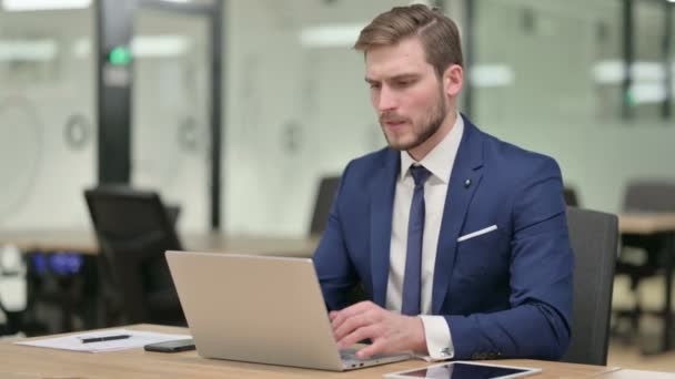 Junger Geschäftsmann hat Kopfschmerzen bei der Arbeit am Laptop — Stockvideo