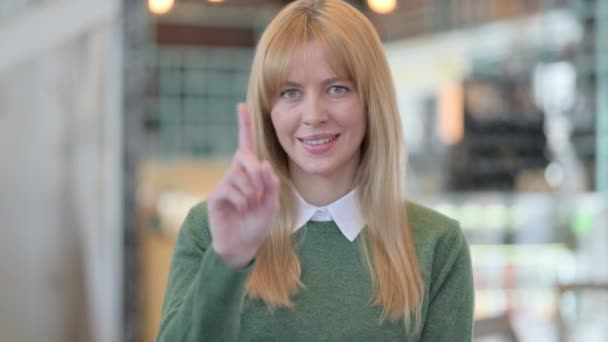 Portret van een jonge vrouw die naar de camera wijst en uitnodigt — Stockvideo