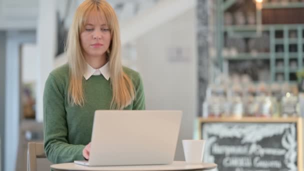 Młoda kobieta odczuwa ból pleców podczas korzystania z laptopa w Cafe — Wideo stockowe