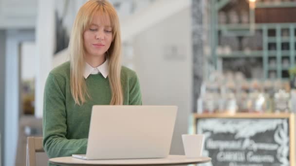美丽的年轻女子在咖啡店的笔记本电脑上工作时喝咖啡 — 图库视频影像