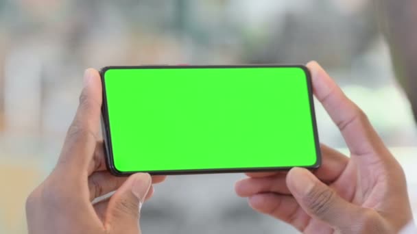 Trzymanie poziomego smartfona z zielonym kluczem Chrome — Wideo stockowe