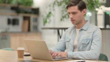 Dizüstü bilgisayarı olan yaratıcı genç adam şok oldu.