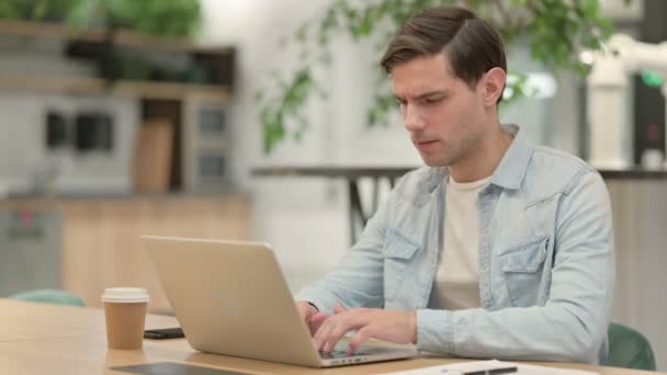 Tvůrčí mladý muž s laptopem s kašlem — Stock video