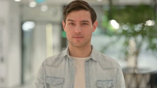 Retrato de un joven creativo apuntando a la cámara, invitando — Vídeos de Stock