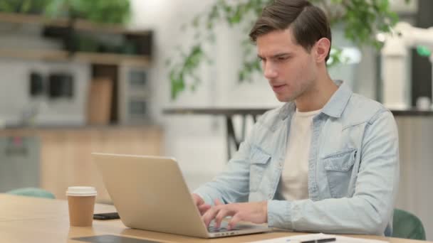Hombre joven creativo con ordenador portátil que tiene dolor de cuello — Vídeos de Stock