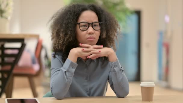Mladá africká žena sedí v kanceláři a přemýšlí — Stock video