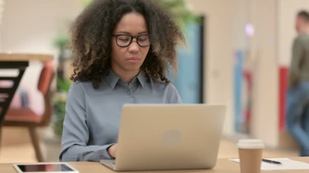 Ung afrikansk kvinna med bärbar dator ler mot kameran — Stockvideo