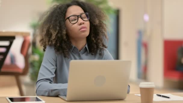 Mujer joven africana con portátil que tiene dolor de cuello — Vídeos de Stock