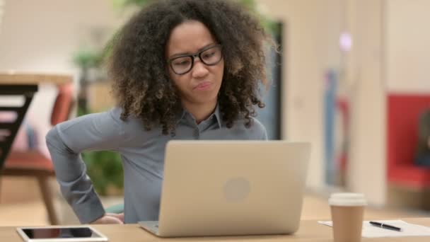 Jeune femme africaine avec ordinateur portable ayant mal au dos — Video