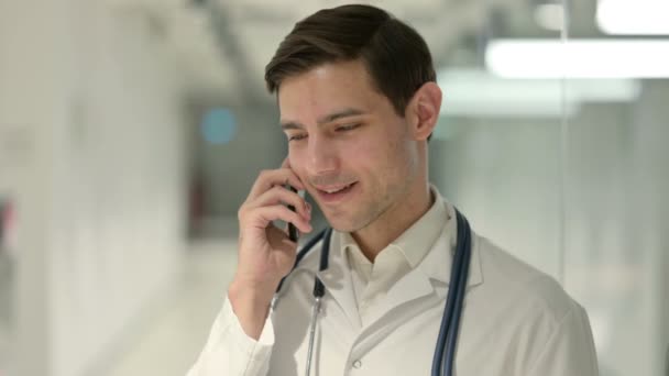 Портрет доктора мужского пола, говорящего на смартфоне — стоковое видео