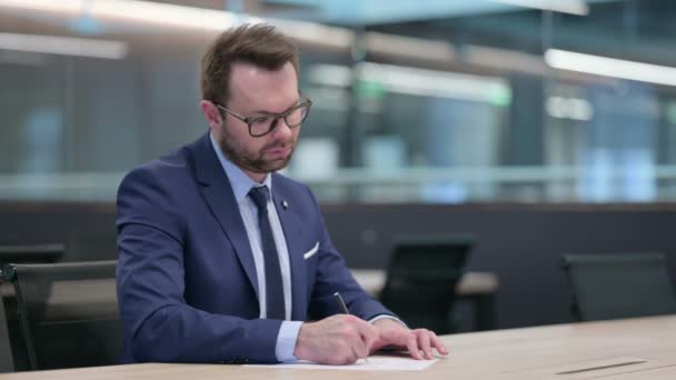 Hardwerkende middelbare leeftijd Zakenman en Schrijven op papier — Stockvideo