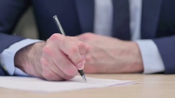 Primer plano de las manos del empresario de mediana edad que escribe en papel — Vídeos de Stock