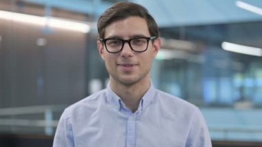 Kameraya gülümseyen genç adamın portresi 