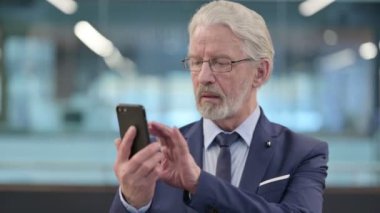Smartphone kullanan Eski İşadamının Portresi