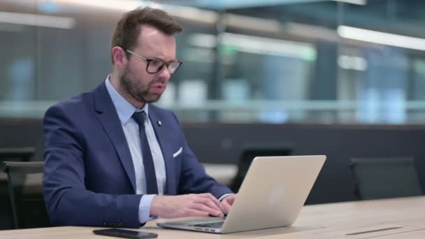 Середнього віку бізнесмен з ноутбуком реагуючи на втрати — стокове відео