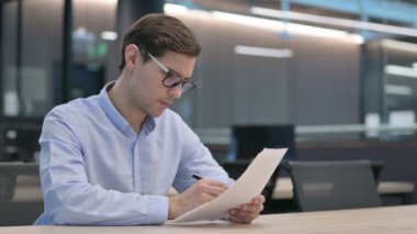 Belgeleri Okurken Başarıyı Kutlayan Genç Adam 