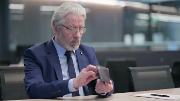 Старый бизнесмен с ноутбуком проверяет пустой кошелек — стоковое видео