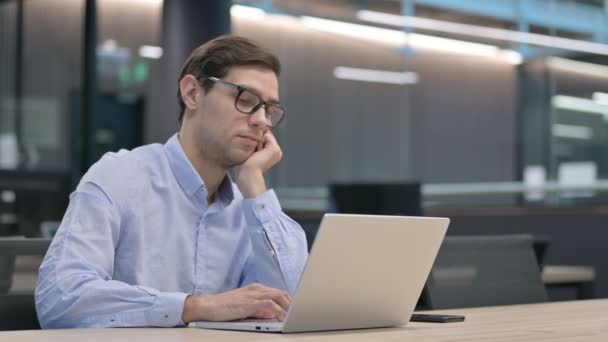 Junger Mann mit Laptop bei der Arbeit — Stockvideo