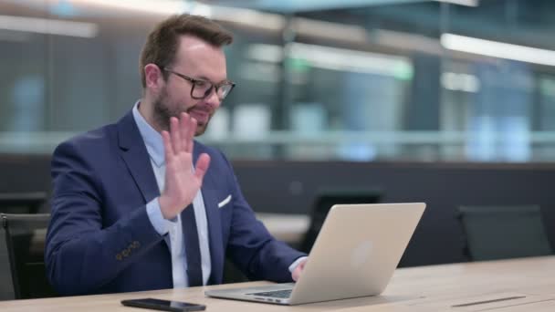 Średniowieczny biznesmen mówiący na wideo czacie na laptopie — Wideo stockowe