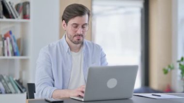 Dizüstü bilgisayarlı Gözlüklü Çekici Adam Kameraya Bakıyor 