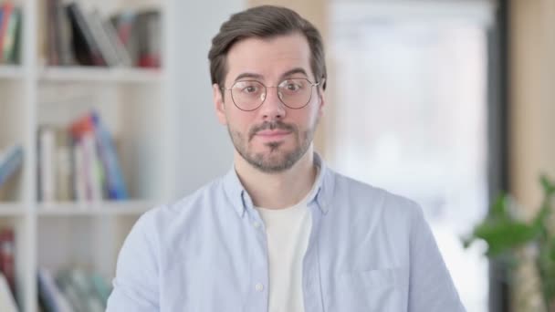 Porträt eines Mannes mit Brille, der einladend in die Kamera zeigt — Stockvideo