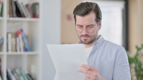 Portret van de mens in glazen leesdocumenten — Stockvideo