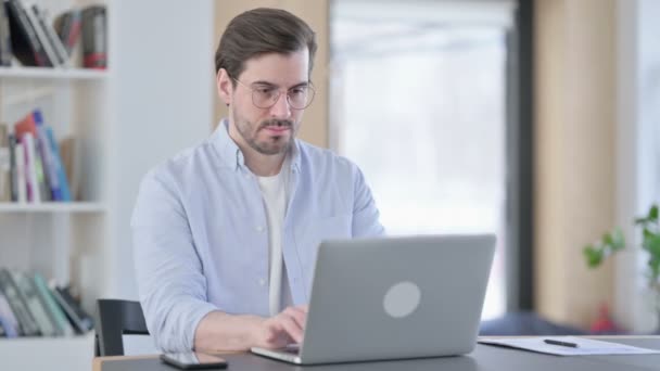 Man in glazen met laptop die nekpijn heeft — Stockvideo