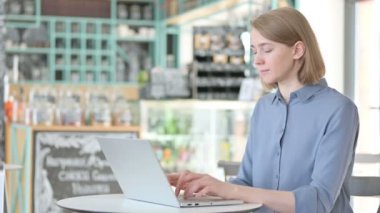 Cafe 'de dizüstü bilgisayarda çalışan genç bir kadın. 