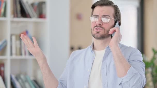 Portrét agresivního muže v brýlích naštvaný na Smartphone — Stock video