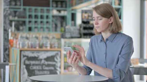 Atractiva mujer joven usando Smartphone en Café — Vídeos de Stock