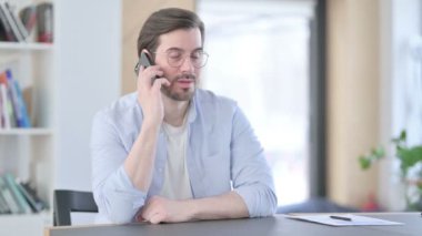 Gözlüklü Adam Ofiste Akıllı Telefonla Konuşuyor 