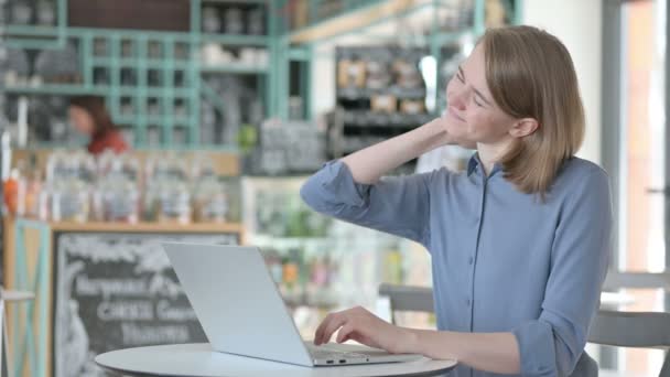 Jovem mulher com dor no pescoço enquanto digita no laptop — Vídeo de Stock