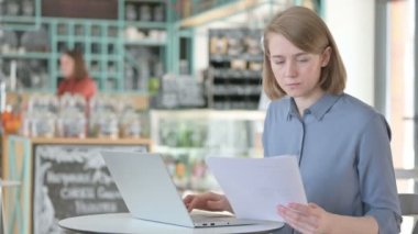 Dizüstü bilgisayar kullanırken Belgeleri Okuyan Genç Kadın 