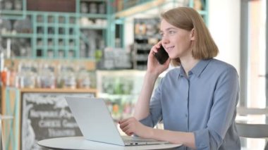 Laptop kullanırken Smartphone 'da Konuşan Genç Kadın 