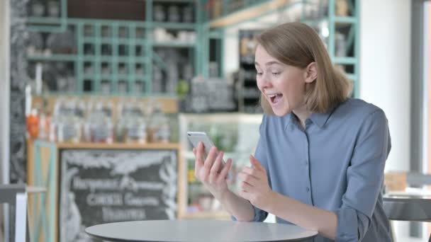 Erfolgreiche junge Frau feiert auf Smartphone — Stockvideo